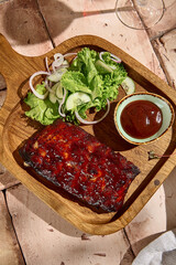 Wall Mural - Authentic BBQ Ribs with Sauce and Fresh Green Salad in Sunlit Still Life Setting