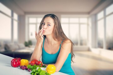 Wall Mural - Happy young woman eating at kitchen at home