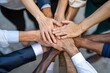 © Surachetsh - Business professionals place their hands together in a show of unity and collaboration, shared commitment to success in a corporate environment.