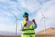 © Adrian Rodd/Stocksy - Engineer uses a pen and notebook to make notes on a wind power plant
