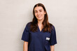 © VICTOR TORRES/Stocksy - Friendly female healthcare worker in blue uniform posing at work