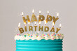 © Ruth Black/Stocksy - Happy birthday cake candles on a decorated birthday cake