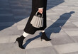 © Ulas&Merve/Stocksy - Fashionable Woman in Black Outfit with Stylish Handbag and High