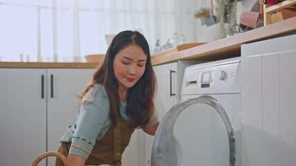 Sticker - Asian beautiful woman put dirty clothes to washing machine in house. 