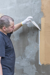 Wall Mural - A man is painting a wall with a brush