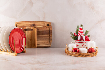 Kitchen marble countertop decorated in a minimalist style for the New Year and Christmas. a dryer with plates, a set of candles, a New Year's gnome.