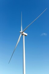 Wall Mural - Wind turbines spinning against a clear blue sky