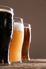 Wall Mural - Glasses with different types of beer on wooden table, closeup