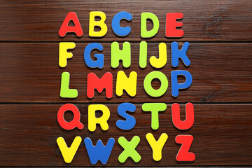 Poster - Alphabetical order. Bright magnetic letters on wooden background, top view