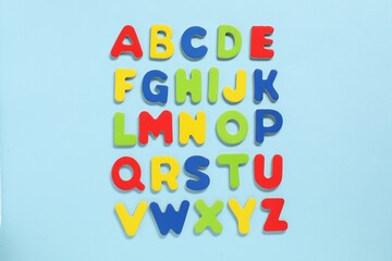 Poster - Alphabetical order. Bright magnetic letters on light blue background, top view