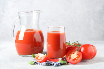 Wall Mural - Tasty tomato juice with fresh vegetables and basil leaves on light grey table