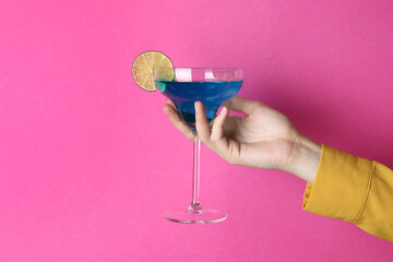 Wall Mural - Woman with glass of refreshing cocktail on pink background, closeup