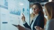 © suriya - Close-up of businesswoman presenting graph on digital whiteboard. Her colleagues are listening and taking notes intently in a modern and stylish conference room