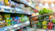 © Gadiel - shopping basket with fresh vegetables and food in supermarket, blurred background