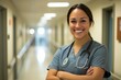 © robertuzhbt89 - A smiling male healthcare professional wearing scrubs and a stethoscope, standing in a hospital corridor. The background is softly blurred, emphasizing the subject's friendly demeanor.