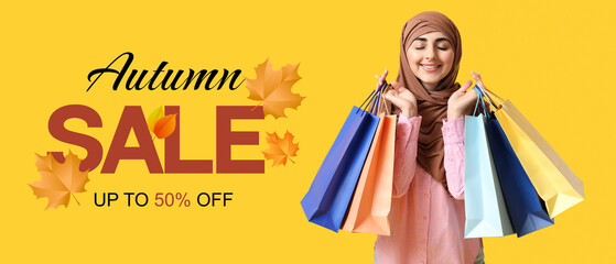 Happy Muslim woman with shopping bags on yellow background