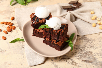 Plate with pieces of tasty chocolate brownie and ice cream on grunge background