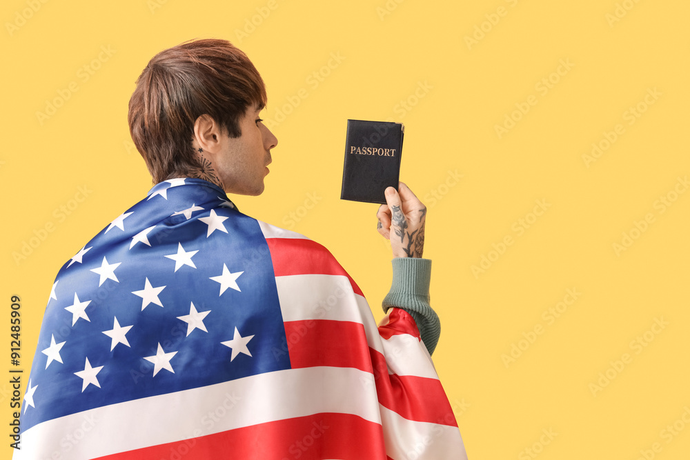 Handsome young man with USA flag and passport on yellow background, back view. Immigration concept