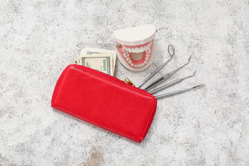 Wall Mural - Wallet with money, jaw model and dental tools on light background