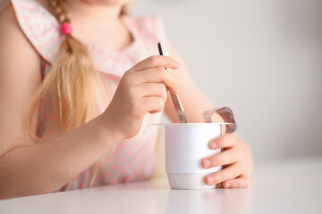 Sticker - Cute little girl with yogurt at home