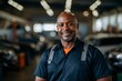 © Baba Images - Portrait of a smiling middle aged African American male car mechanic