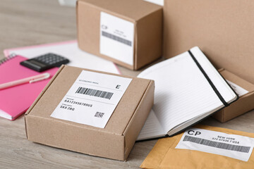 Poster - Parcel boxes with notebook on table at postal warehouse, closeup