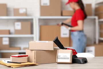 Canvas Print - Parcel boxes with packing tape dispenser on table at postal warehouse