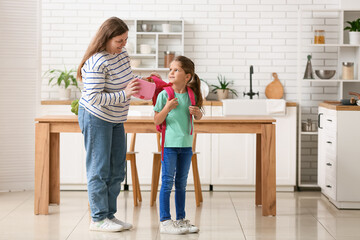 Wall Mural - Mother with her daughter packing lunchbox for school in kitchen