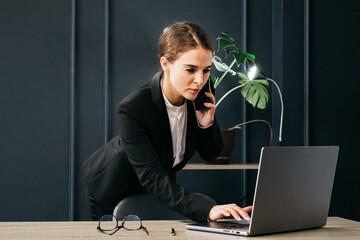 Confident businesswoman using her smartphone in a modern office. Ideal for themes of professional communication, business technology, and corporate success.