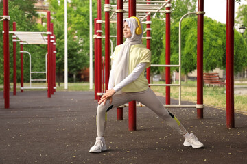 Poster - Sporty Muslim woman in headphones training outdoors