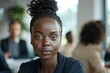 © CojanAI - Young black businesswoman in focus during a office meeting