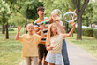 © Pixel-Shot - Happy family with cute children blowing soap bubbles in park