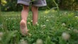 © maxximmm - little girl walks on the grass barefoot in the park. happy family kid dream concept. bare feet close-up walks on the grass in summer lifestyle child. daughter walks barefoot on the grass in the park