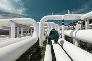 Wall Mural - Male worker inspection at steel long pipes and pipe elbow in station oil factory during refinery valve of visual check