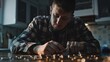 © A Denny Syahputra - A young man focused on organizing coins at a wooden table while in a warmly lit kitchen