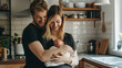 © GraysonStock - a couple holding their baby in their arms in the kitchen of their home