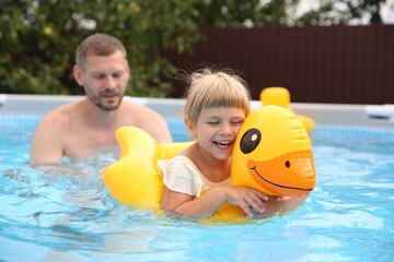 Canvas Print - Happy daughter and her father swimming in pool