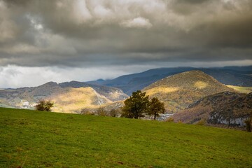 Canvas Print - Picturesque landscape of rolling hills under a dramatic cloudy sky