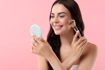 Canvas Print - Beautiful makeup. Smiling woman applying blush with brush on pink background