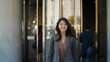 © l1gend - Stylish 25-Year-Old Asian Woman Smiling While Walking Out of Office Building in Los Angeles