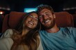 © Milos - A couple is captured sharing a happy moment while enjoying a movie in a theater, their faces lit up with joy and laughter, embodying love and togetherness.