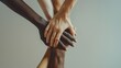 © VK Studio - Diverse hands stacked together vertically, showcasing unity and mutual support among people of different skin tones against a neutral background.