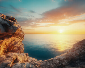 Wall Mural - a rocky cliff overlooks a calm ocean with a beautiful sunset in the background