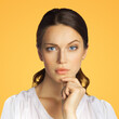 © vgstudio - Portrait of puzzled, shocked, astonished woman businesswoman wear white confident clothing, isolated over against orange yellow color studio wall background. Square image.