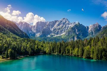 Wall Mural - Picturesque lake Lago Fusine in Italy. Fusine lake with Mangart peak on background. Popular travel destination of Julian Alps. Location: Tarvisio comune , Province of Udine, Italy, Europe.