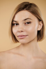 Wall Mural - Appealing woman looking at camera on pastel backdrop.