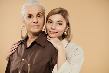 Wall Mural - A mature woman embraces her adult daughter, showcasing their close relationship.