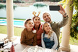 © Chanelle2000/peopleimages.com - Family, happy and selfie for Christmas, bonding and joy outdoor with fun, smile and pool in backyard. Mom, dad and children for holiday, celebration and social media with support, memory and embrace