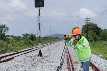 Surveyor builder site engineer with theodolite total station at Railway site outdoors during surveying work