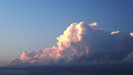 Wall Mural - time lapse of late day storm clouds that are lit by a setting sun. the pink colors fade to all blue 